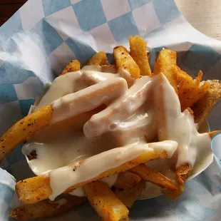 Seasoned fries w/ queso cheese.