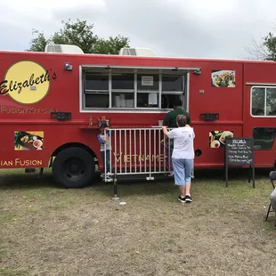 a woman ordering food from a food truck