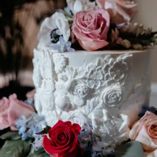 a white wedding cake with pink and blue flowers