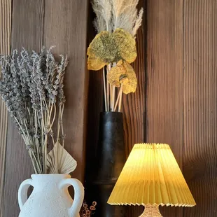 a vase with dried flowers and a lamp