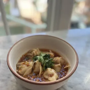 a bowl of soup with dumplings
