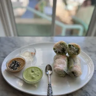 a plate of food with dipping sauces