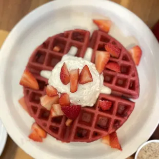 a waffle with strawberries and whipped cream
