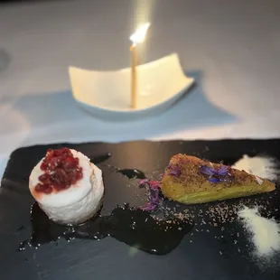 three desserts on a black plate