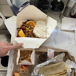 a tray of food and a person's hand