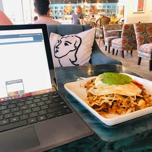 a laptop and a plate of food