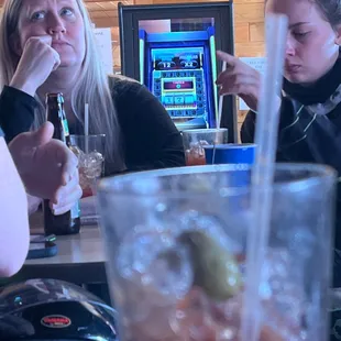 two women sitting at a table with drinks