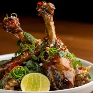 a plate of chicken with a lime wedge