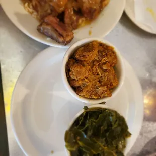 Oxtails with gravy on rice, dressing and collard greens