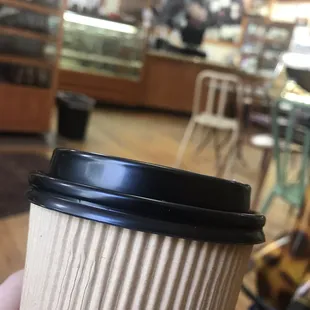 a hand holding a coffee cup