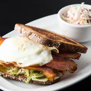a plate with a sandwich and a bowl of coleslaw