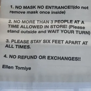 a sign stating customers not to wear masks