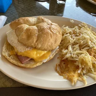 Croissant egg, cheese and ham with hash browns