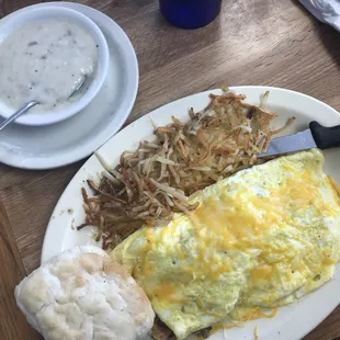 Meat lover's omelet with hash browns, biscuit, and side of sausage gravy