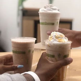 two people holding cups of coffee