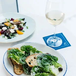 a plate of salad and a glass of wine
