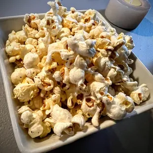 a bowl of popcorn and a candle