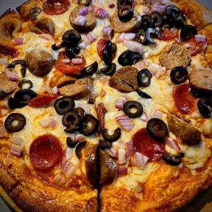 a pizza with pepperoni, onions, mushrooms, and sausage
