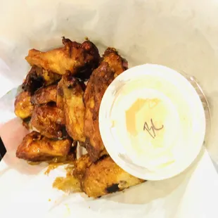 a basket of chicken wings with dipping sauce