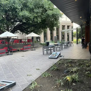 Outside. Lots of tables, outdoor bar seating/serving, and cornhole