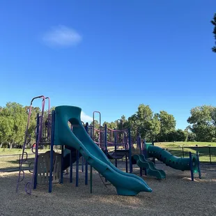 This park is decent, good location, cool lake, two fenced in play sets, benches in the shade, lots of geese and a dude asleep on the grass.