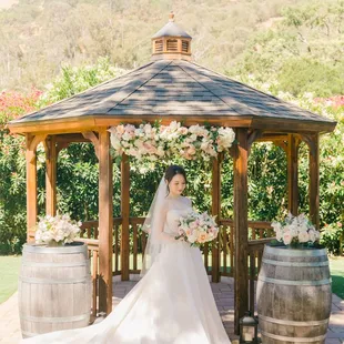 a bride standing in front of a gazebo