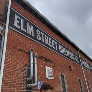 a man standing in front of a brick building