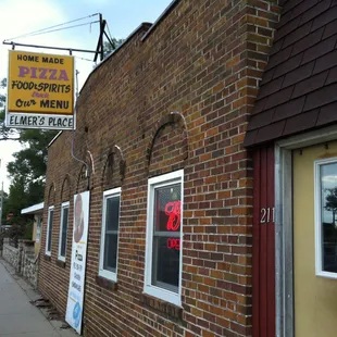 a brick building with a pizza sign