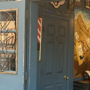 the entrance to a restaurant with a mural on the wall