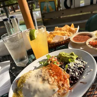 Stacked chicken enchiladas, black beans and guacamole and pico salad.