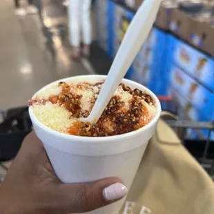 a hand holding a cup of ice cream