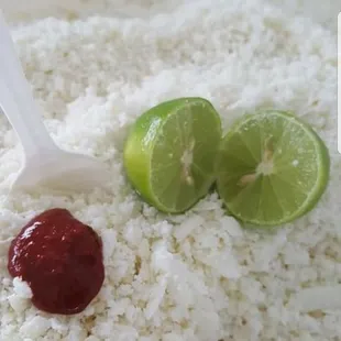 a bowl of rice with a spoon and limes