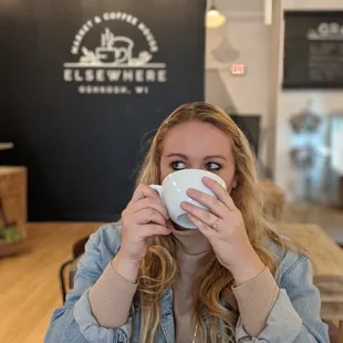 a woman drinking a cup of coffee