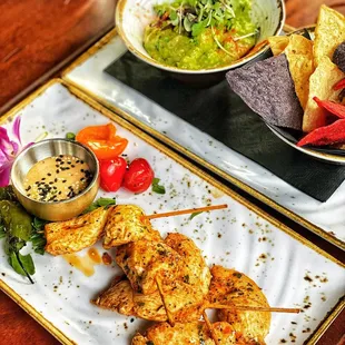 Chicken skewers, chips and guacamole
