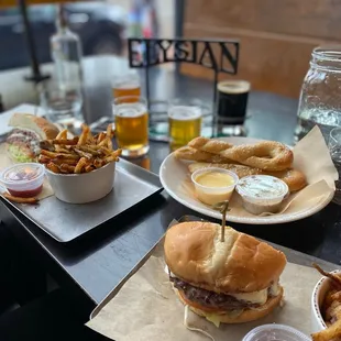 Burger, fries, flight of beer and pretzel.