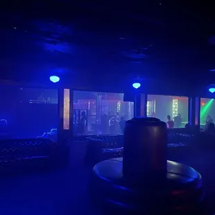 Dimly lit, Main area with open seating and in the far background people can be seen dancing.