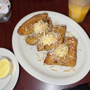 a plate of french toast and a cup of orange juice