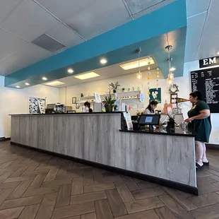 a woman standing at the counter of a coffee shop