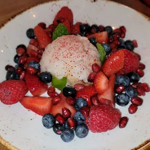 Coconut Rice Pudding with cardamom, cinnamon, berries, pomegranate molasses, and mint