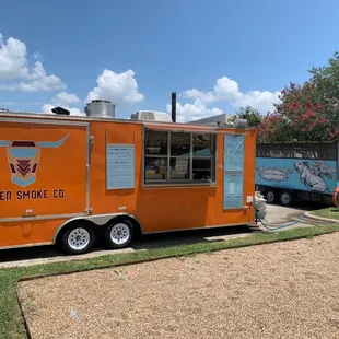 an orange food truck parked in front of a building