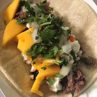 Resonance taco, smoked then braised lamb shoulder, goat cheese, mango, onion, cilantro.