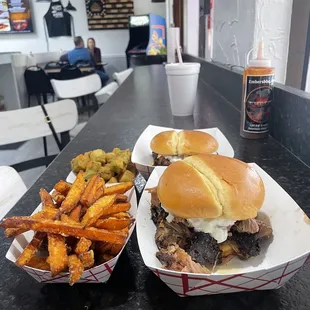 two sandwiches and fries on a table