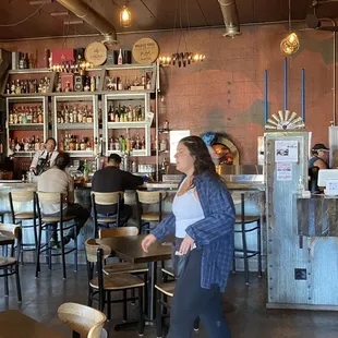 a woman standing in front of a bar