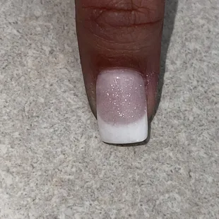 Black lint trapped on the center of nail.