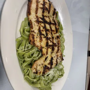 a grilled chicken breast on a bed of lettuce