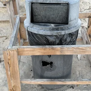 Trash can near the stairs leading from the beach to the upper deck area.