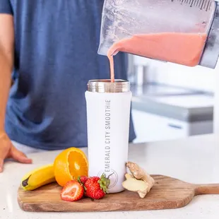 a man pouring a smoothie into a blender