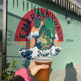 a hand holding a beer