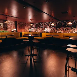 he interior of a restaurant with yellow booths and stools