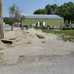 a green building with a sign on the side of the road